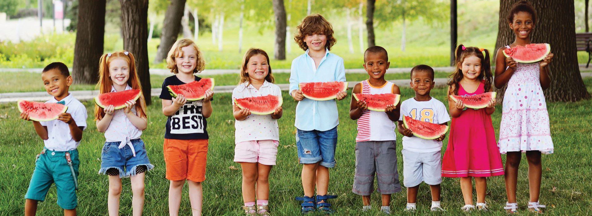 A line of kids eating watermelon slides